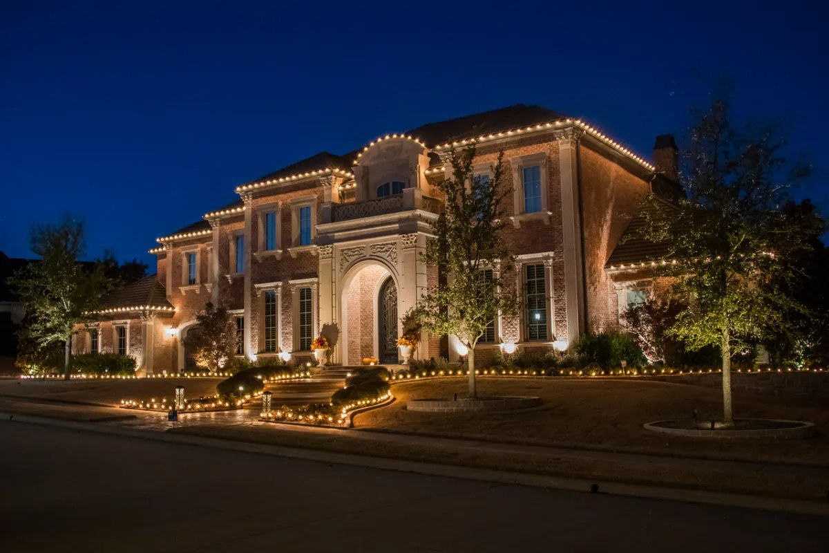 Grand entrance with columns wrapped in garland and warm white lights